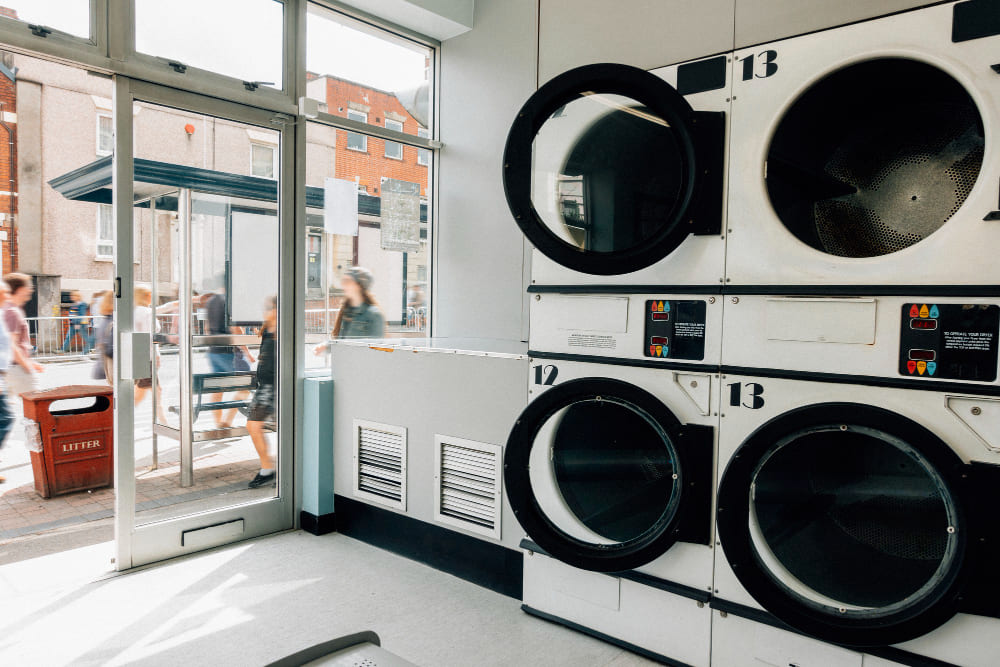 Laundromat interior with rows of washers and folding tables